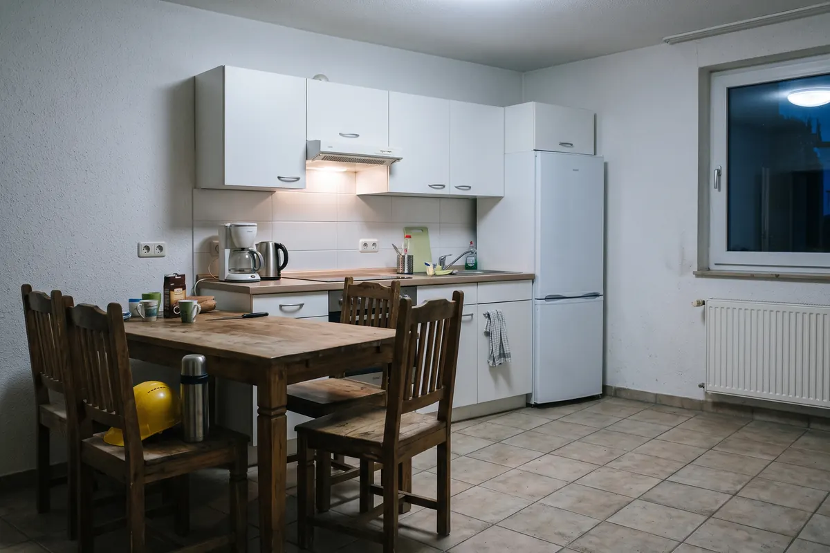 Einfache Küche einer Monteurwohnung mit Esstisch für vier Personen