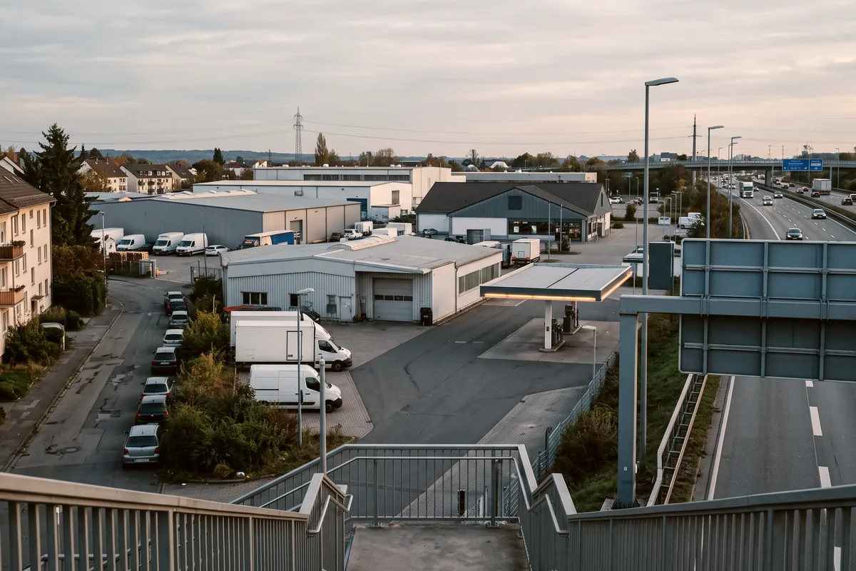 Gewerbegebiet an einer Autobahnauffahrt mit Wohnhäusern am Rand, guter Standort für Monteurzimmer